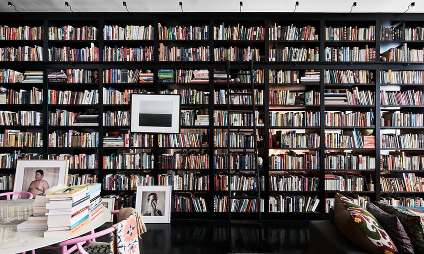 Novelist Hanya Yanagihara's one-bedroom New York apartment where she lives with 12,000 books and her art collection. She always arranges the books alphabetically. The flat has no dividing walls; instead, the vast, double-sided bookcase acts “as a kind of suggestion of a wall”.