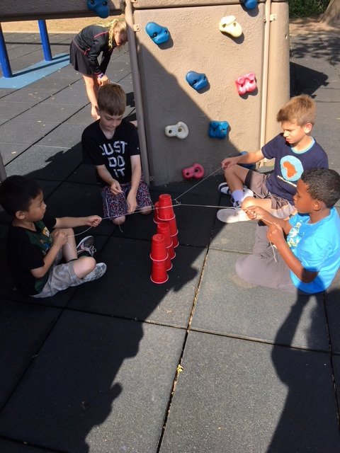 LHTanglenSchool's tweet photo. Mrs. O'Neil's second graders met with their buddies from Ms. Deehr/Hovanetz fifth grade class for a cup building challenge. Without using hands, and only a rubber band and strings, they needed to work together to build a pyramid of cups. Awesome team building! #TanglenPride https://t.co/wuUkTd9l6C