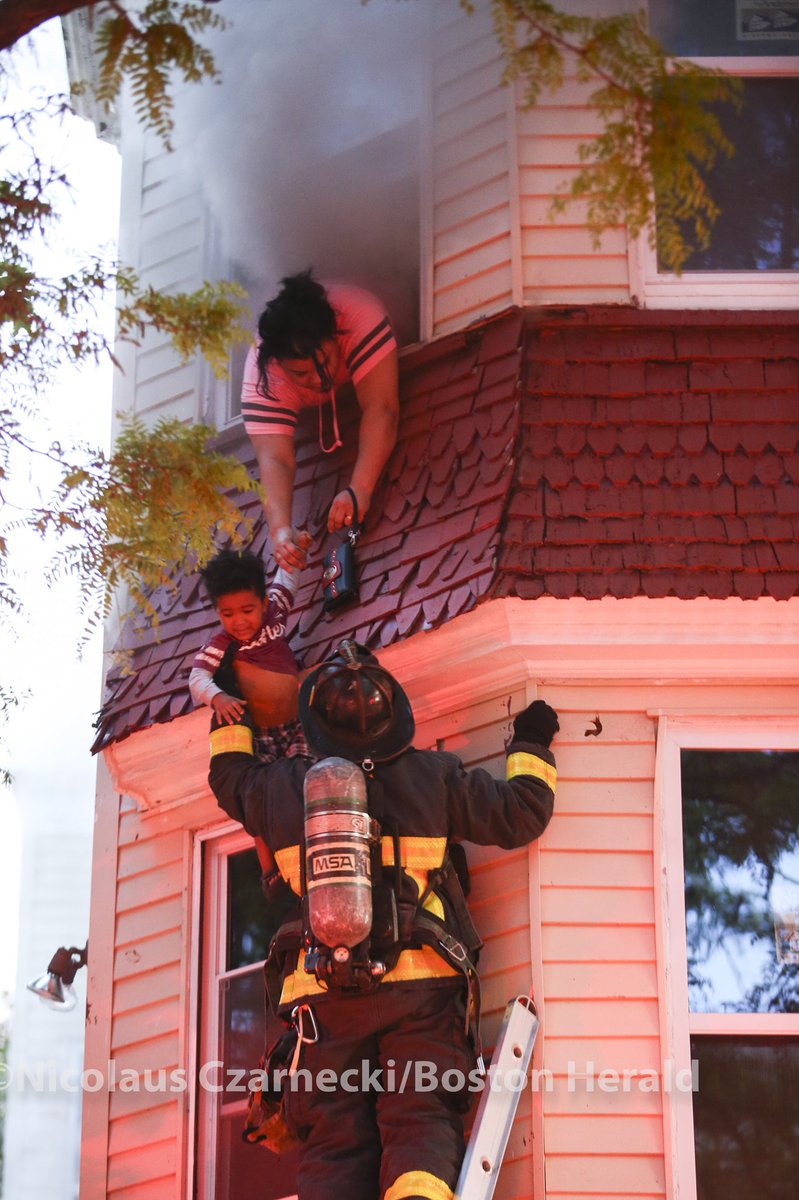 nicoczar's tweet image. A mother hands her child to a firefighter as boston fire crews work quickly to extinguish a two-alarm fire on Woodward Park Street in Boston on Wednesday, May 30, 2018. Boston Herald Staff photo by Nicolaus Czarnecki @bostonherald #bostonfire @BostonFire #bfd #bostonfd