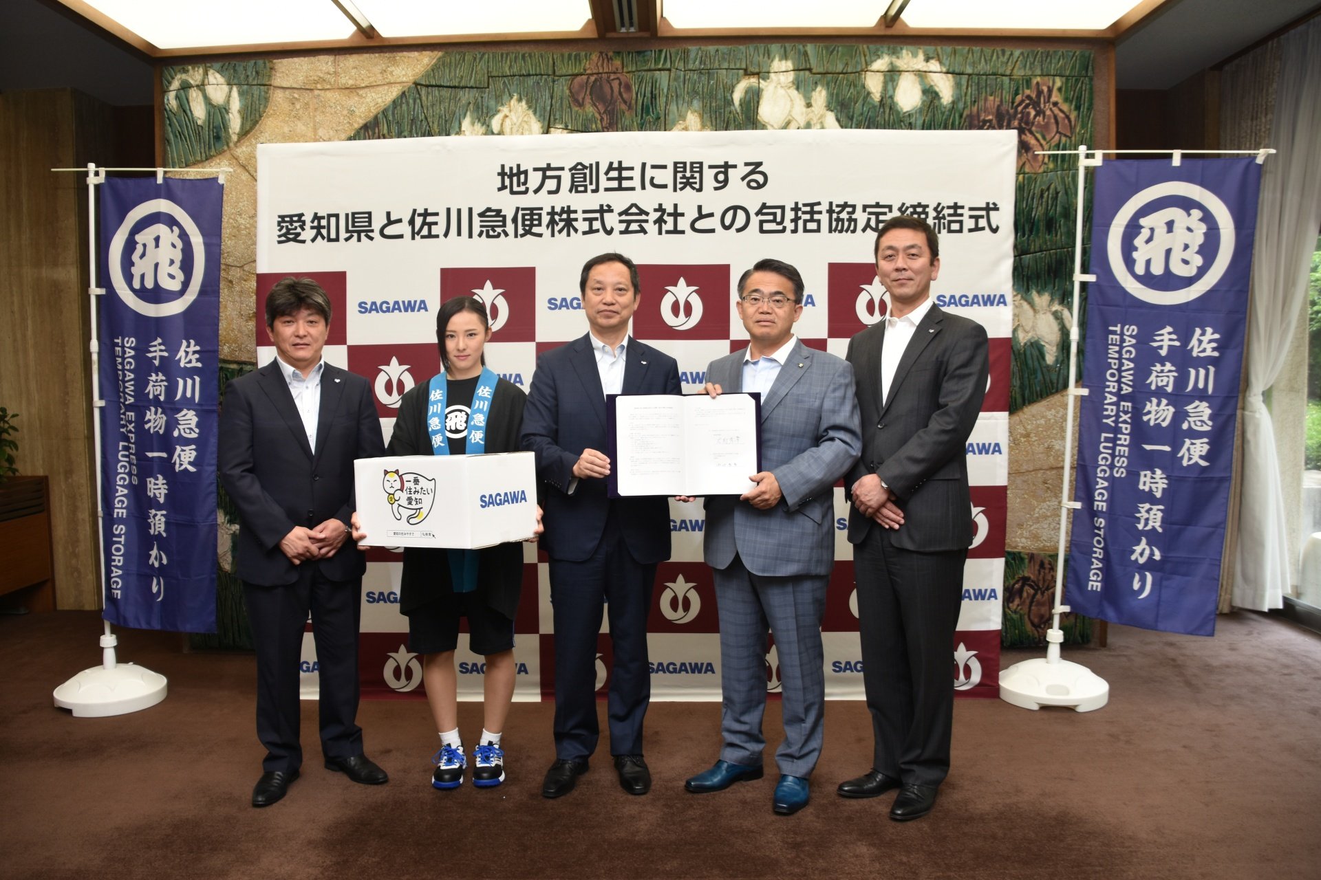 大村秀章 地方創生に関する包括協定を締結した 佐川急便 株 の内田浩幸取締役 広瀬禎幸中京支店長 河村康之名古屋営業所長と 佐川女子 の林葉月さんが手にしているのが 一番住みたい愛知 の招き猫を印刷したダンボール箱です 愛知県庁正庁にて
