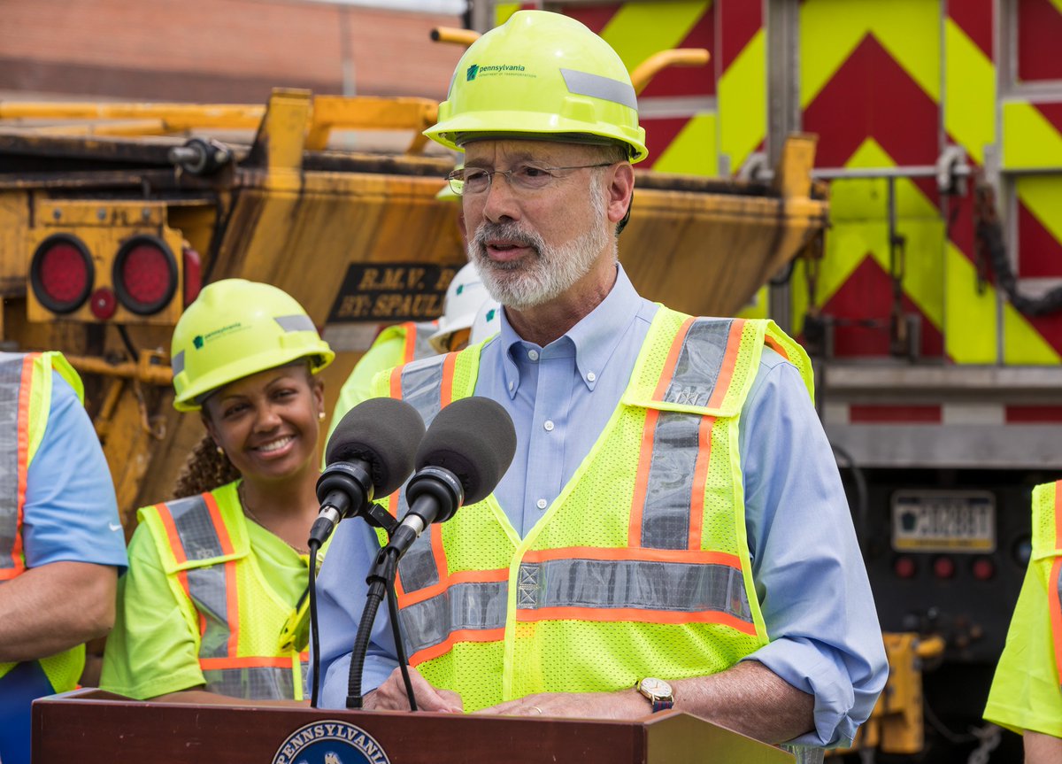 Image of Governor Tom Wolf wearing PennDOT attire and speaking from behind a podium.