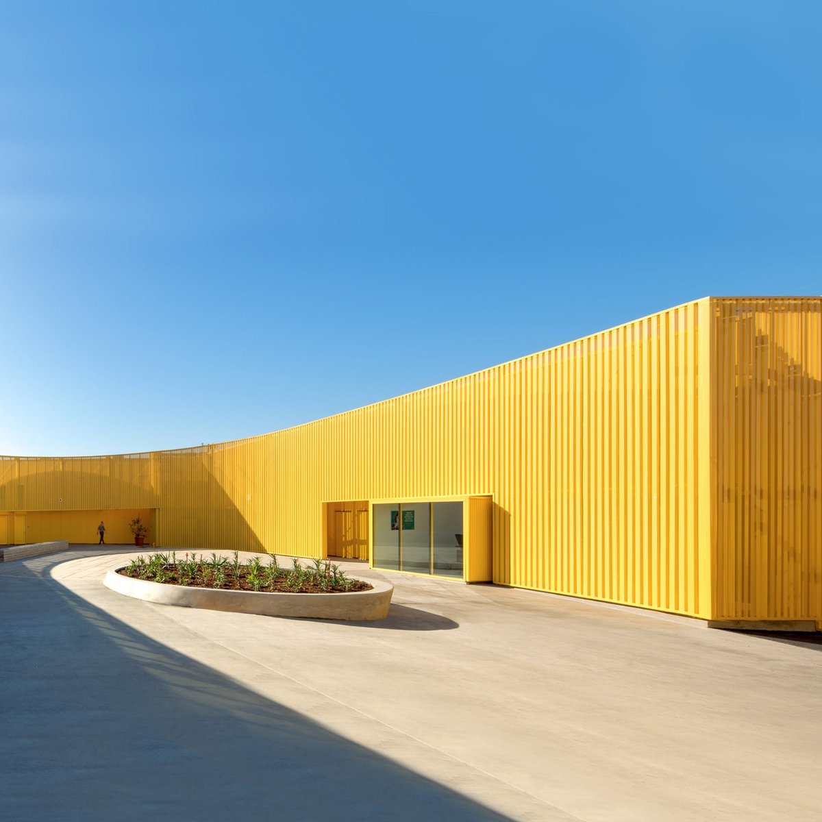 dezeen's tweet photo. Yellow metal walls wrap Animo South Los Angeles High School by Brooks + Scarpa https://t.co/FJyOmKTGQO https://t.co/SR9lsFHc9j