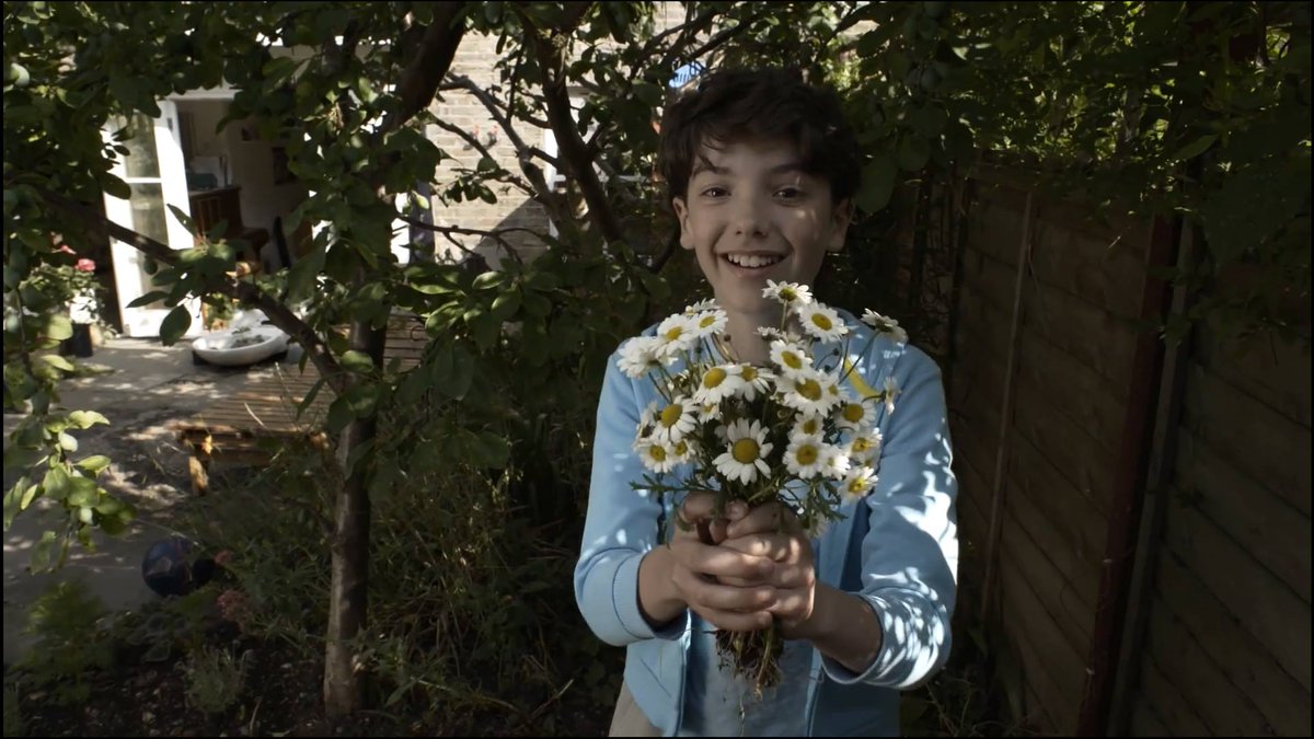 Shot of a young boy in the garden holding a bunch of flowers and smiling