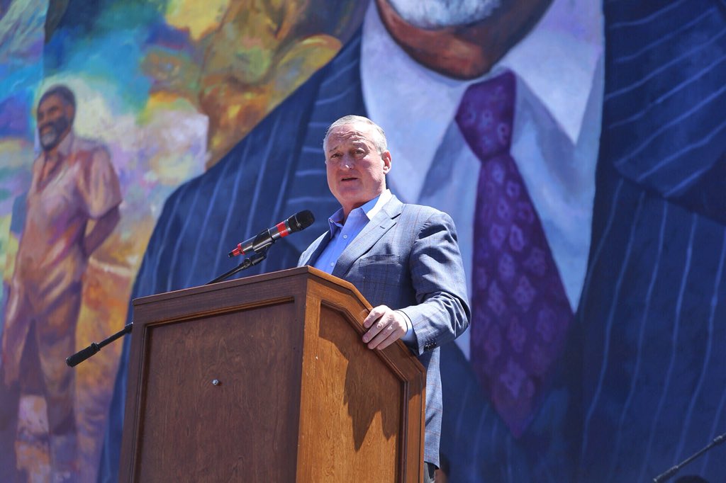 The Mayor speaking at a podium before the Ed Bradley mural.