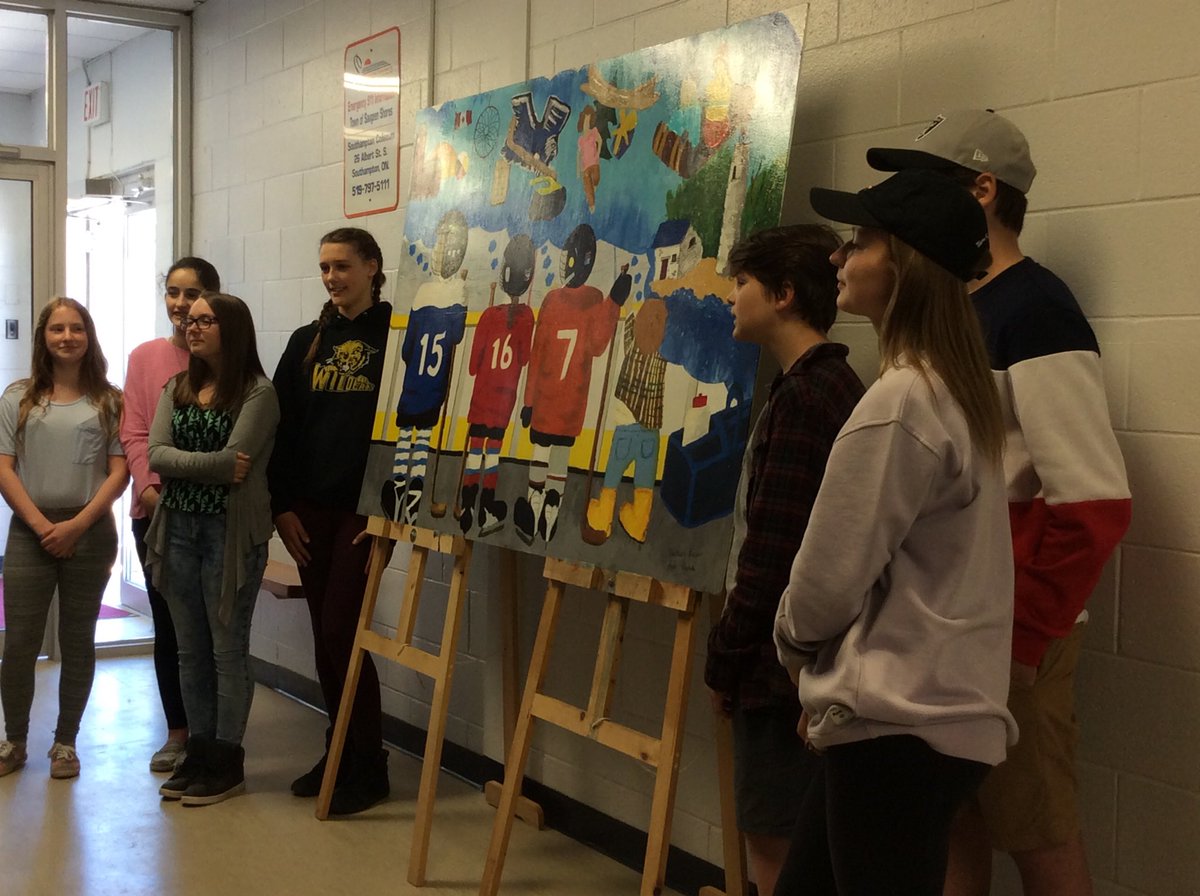 Zach Leaver and Layla Cushnie presenting their mural for the Southampton arena, with the help of their friends.