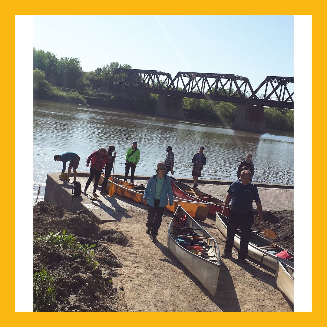 ManitobaMuseum's tweet photo. It's #commuterchallengemb week! Pictured here are 5 of the 6 boats carrying 12 canoe commuters that arrived from Charleswood on the Assiniboine River Monday Morning. Also pictured are our staff getting ready to portage the canoes! #sustainabilitiy #environment #greenactionctr https://t.co/hteisHRcNZ