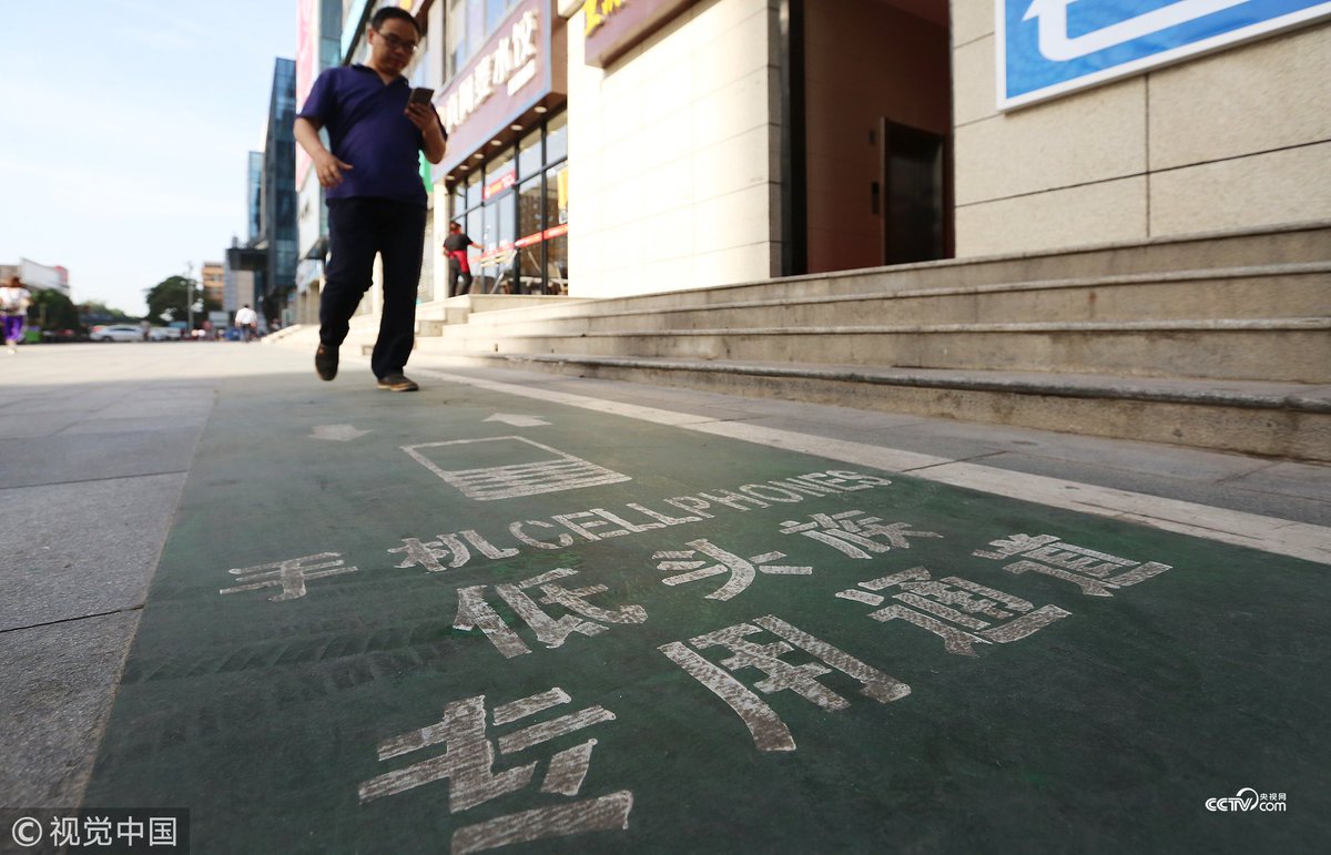 CCTV's tweet photo. 【西安街頭現低頭族專用通道 你怎麽看？】近日，西安街頭出現了一條爲"低頭族"設計的專用通道，該通道寬約一米，寫著"低頭族專用通道"，"低頭族"可在上面一邊玩手機一邊走路。對此，有市民覺得很好，可以提高安全保障；也有市民認爲，走路就不應該玩手機，不能縱容"低頭族"。你怎麽看？ https://t.co/Ap1l4bipDi