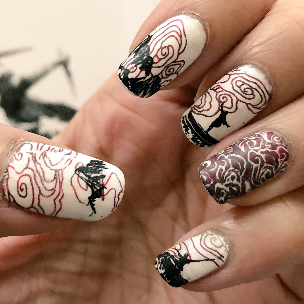 Nailart depicting mountains, swirly clouds and silhouettes of martial artists