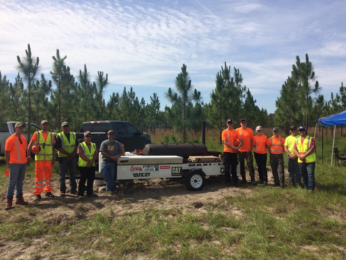 coastalpinestc's tweet photo. CPTC 2018 Timber Harvesting class enjoyed a cook out at the timber site. Craig Foreman of Yancey Bros. CAT @CaterpillarInc sponsored & prepared the meals. Pictured are the 2018 Timber Harvesting Students, Instructor Carlos Thrift, Instructor Andy Jones & Craig Forman. #Lrn2Live https://t.co/QqJ1GANaoW