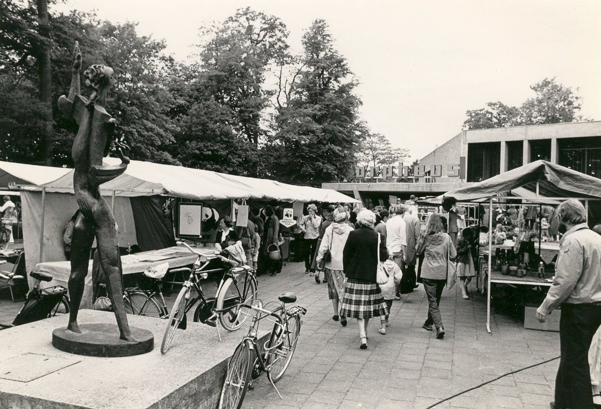 CODAapeldoorn's tweet photo. Vanaf 19 uur vanavond tot zondag half 4 Culturele #Pleinmarkt. Voor de vijftigste keer! Foto van de markt in 1983, toen de Orpheus van Zadkine nog vóór #TheaterOrpheus stond. Foto #CODAarchief. Kijk ook eens op het Geheugen van Apeldoorn: https://t.co/dP7smmkuN5 https://t.co/VLM81bxmpm