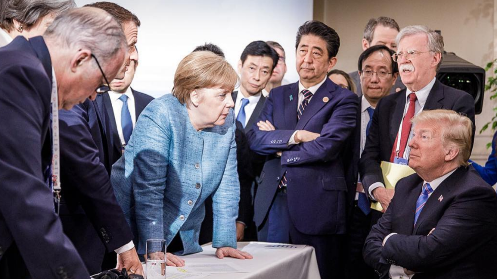 thehill's tweet photo. Merkel shares viral photo of herself staring down Trump https://t.co/9deGheiF6e https://t.co/BSZmQDkPrl