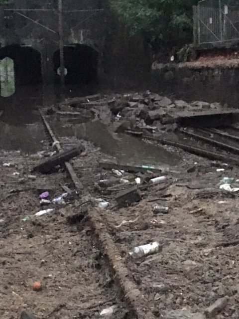 ScotRail's tweet photo. NEW: Heavy rain flooded the railway at #Dalmuir yesterday and the line remains closed. This is because the track has been damaged, a lineside wall has fallen onto the track, and there’s a significant amount of debris to be cleared. ^CT https://t.co/1tUul2Pk97