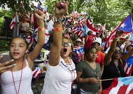 revelers with flags of Puerto Rico participate in celebration