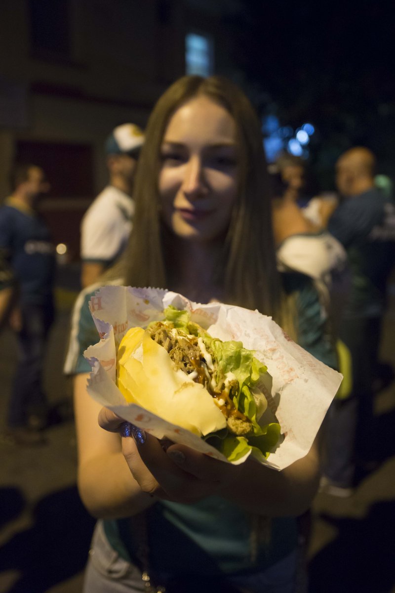 Lufthansa_BR's tweet photo. A experiência de ir ao campo só é completa se você come um sanduíche de pernil! A nossa convidada russa caiu de cabeça no momento e se deliciou com um lanche bem caprichado depois do clássico Palmeiras x São Paulo. #CheckInMoscow https://t.co/0fk9CUSvsv