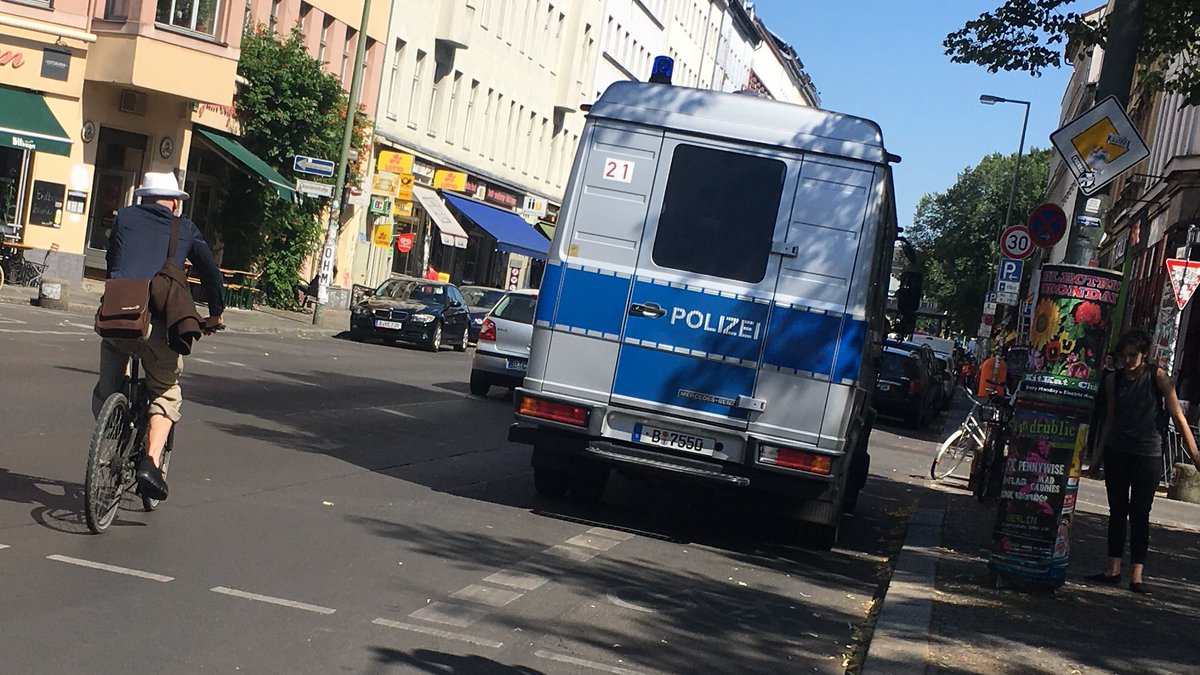 Mannschaftswagen der Polizei steht auf dem Fahrradstreifen am Heinrichplatz und Fahrradfahrer muss auf die Fahrbahn ausweichen.