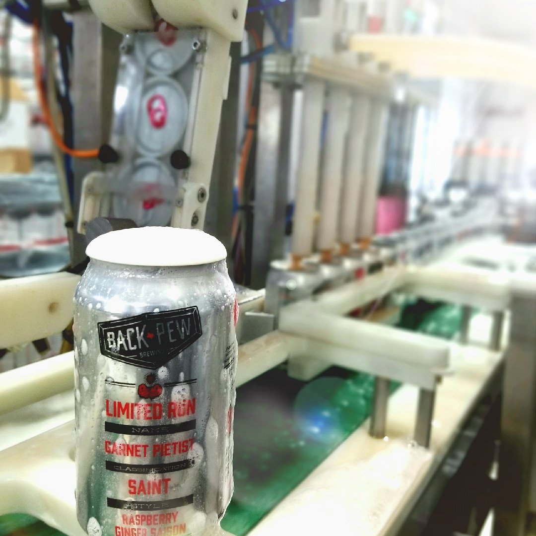 BackPewBrew's tweet photo. Garnet Pietist is going in cans! 400 cases head to market late this week/early next week, kegs will be rolling too. Thanks to @AmericanCanning for getting it in these pretty thangs (and snapping a great picture) #bpsaintlife #comeallyethirsty #raspberry #ginger #saison https://t.co/G06WBBhIfB