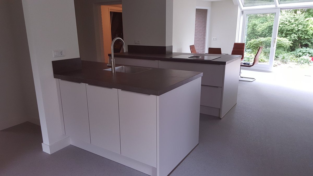 Onze klant vroeg een strak ontwerp. De combinatie van witte en houten fronten met zwarte @Pilgrim apparatuur maakt het een strak vormgegeven #keuken. Een keramiek blad, voorzien van een @BORA kookplaat en <a href="/quooker/">Quooker HQ</a>, maakt dat deze keuken ook nog eens zeer gebruiksvriendelijk is.