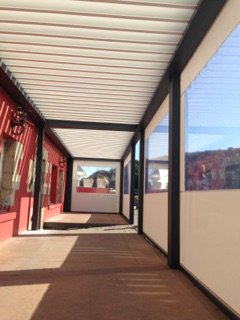 Le Café du Port à Plouezoch, 
Réalisation de Cyb Stores Brest - Voilerie Brestoise
2 pergolas bioclimatiques aluminium couplées équipées de stores zip intégrés dans la structure pour une optimisation de la surface d’accueil.