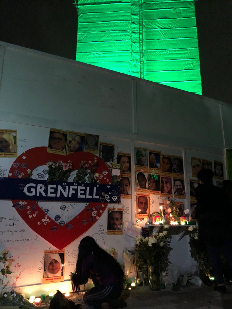 Grenfellspeaks's tweet photo. Crowds gather at the base of a Green lit #Grenfell Tower tonight amidst tributes and flowers to remember those lost at #Grenfell
#GrenfellTowerFire #GrenfellTower #Grenfell https://t.co/27ajSjCbae