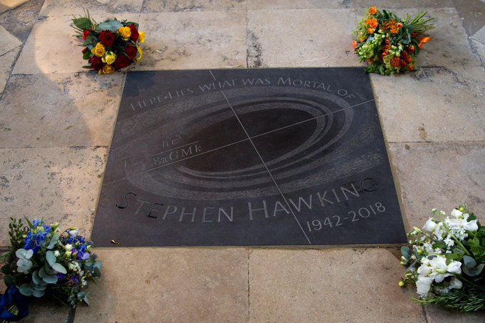 The memorial stone of Stephen Hawking surrounded by flowers laid by his family