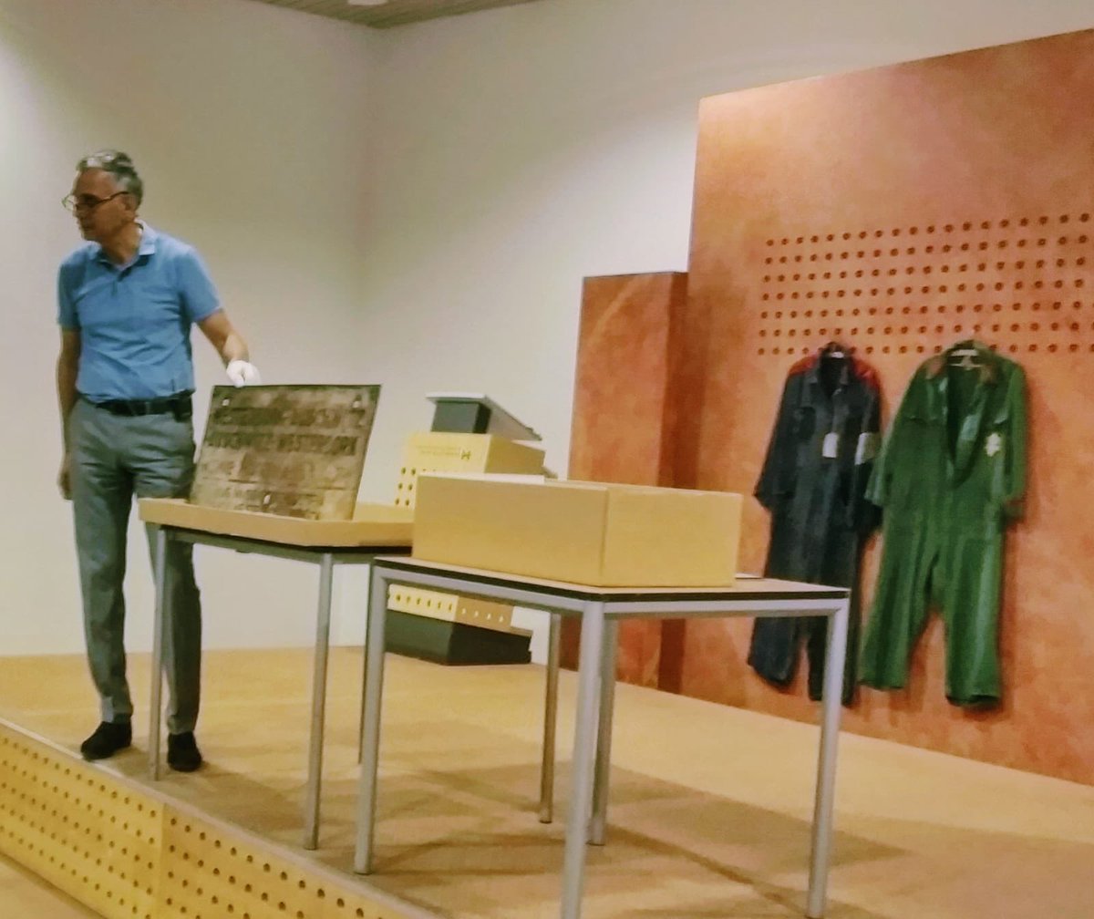 kampwesterbork's tweet photo. En conservator Guido Abuys van @kampwesterbork toont een deel van de collectie. Hier laat hij het bord Westerbork-Auschwitz zien. #holoedu18 https://t.co/iknycWY6a6