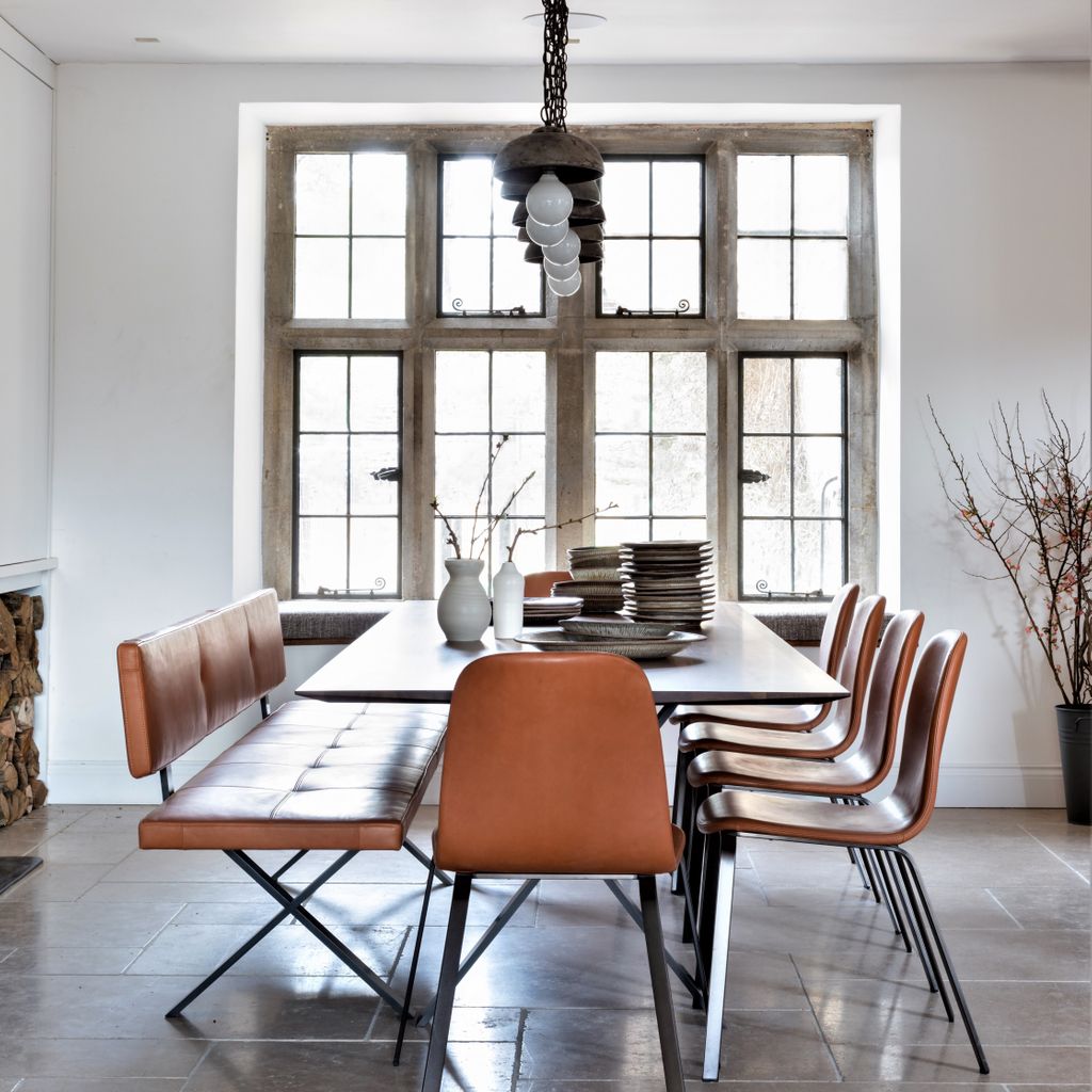 People often ask us if contemporary furniture is 'right' in an historic Cotswold home with its stone mullion windows. The classic simplicity of this American Walnut and steel table, leather benches and chairs sits beautifully against this historic window.