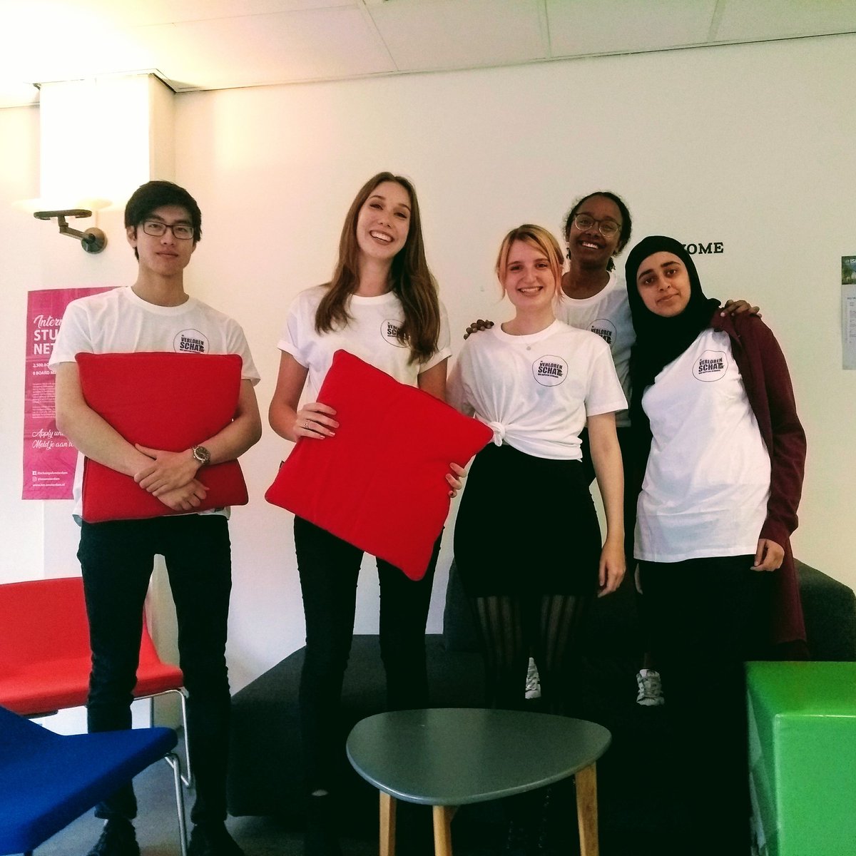 5 studenten die allemaal een T-shirt aanhebben van het door hen ontwikkelde spel.