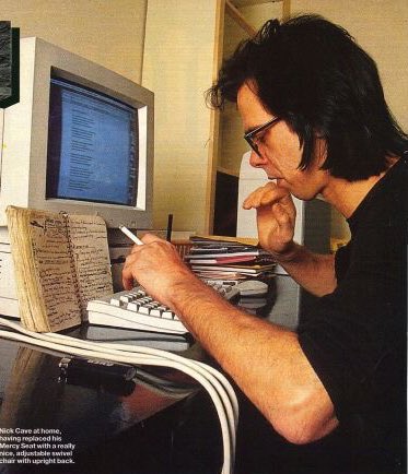 cavethings's tweet image. nick cave working on a computer