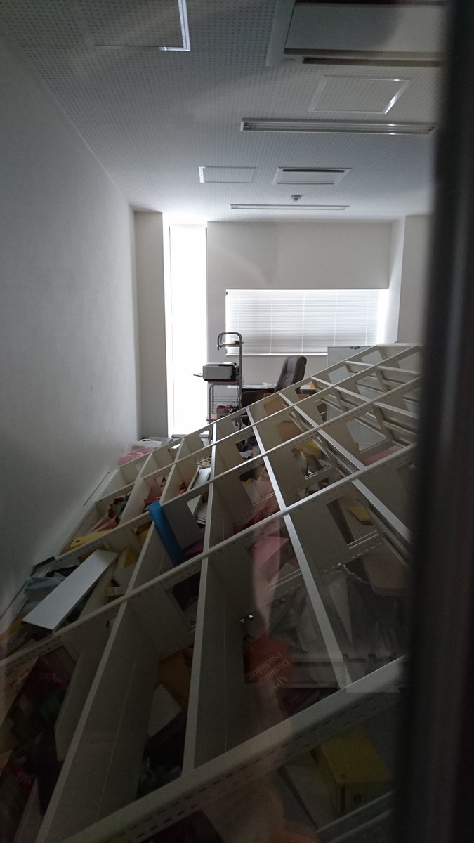 立命館大学総合心理学部 悲報 ８階 岡本直子先生の研究室 書架が倒れたため ドアが開きません 業者の方に開けてもらうために研究棟ロビーで待機中です ドアの小窓から撮影