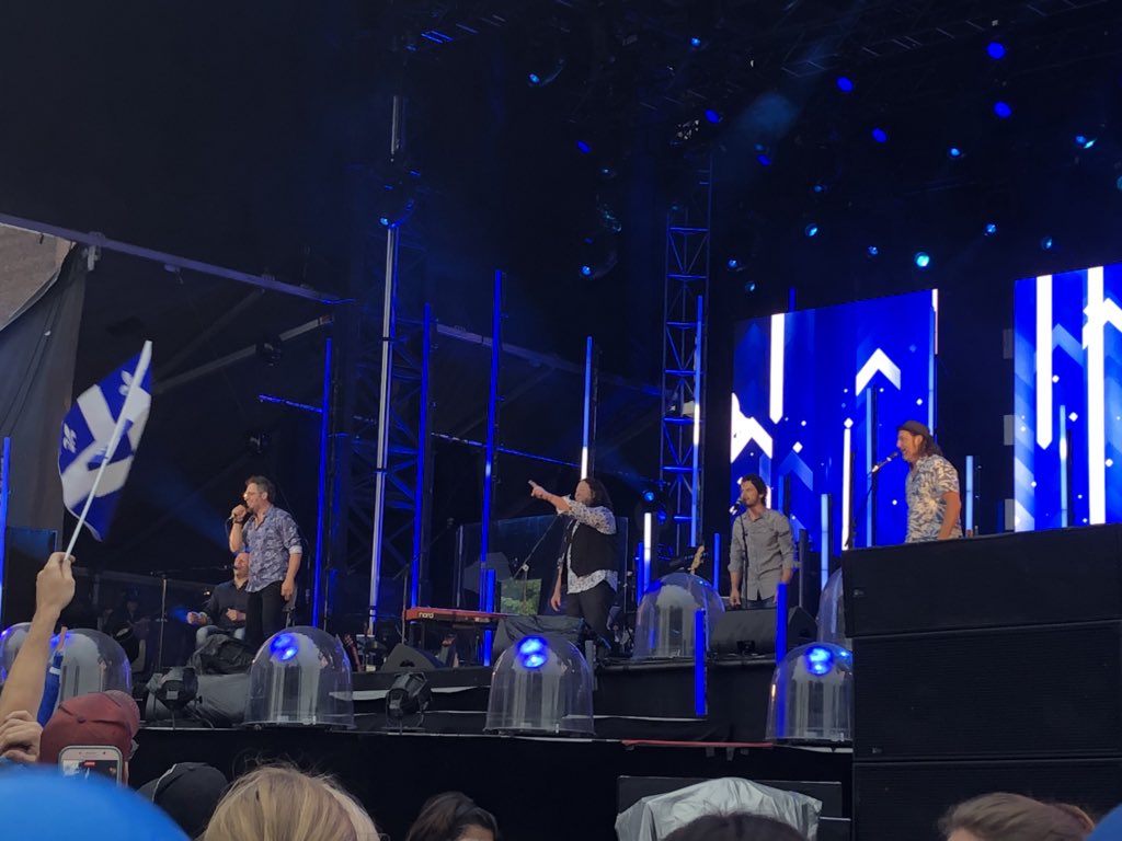 dbrunetv's tweet photo. La pluie n’a pas découragé les Montréalais qui assistent au spectacle de la Fête nationale à la place des festivals. Le groupe le Vent du nord présente la première partie. https://t.co/QIVyxskmEY