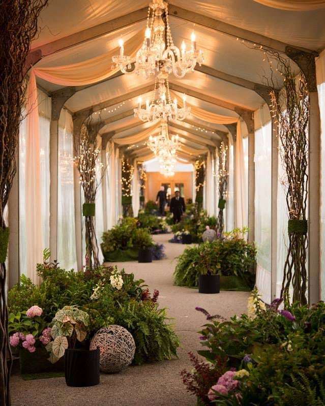 Keeping it enchanting, this entrance hallway featured lots of lush greenery and curly willow with lights to make it absolutely magical. || Planner: @mdurpettievents | Photographer: @davidturnerphoto | Cake: @elysiarootcakes | Venue: @chicagoparks | Catering: @paramountevents…