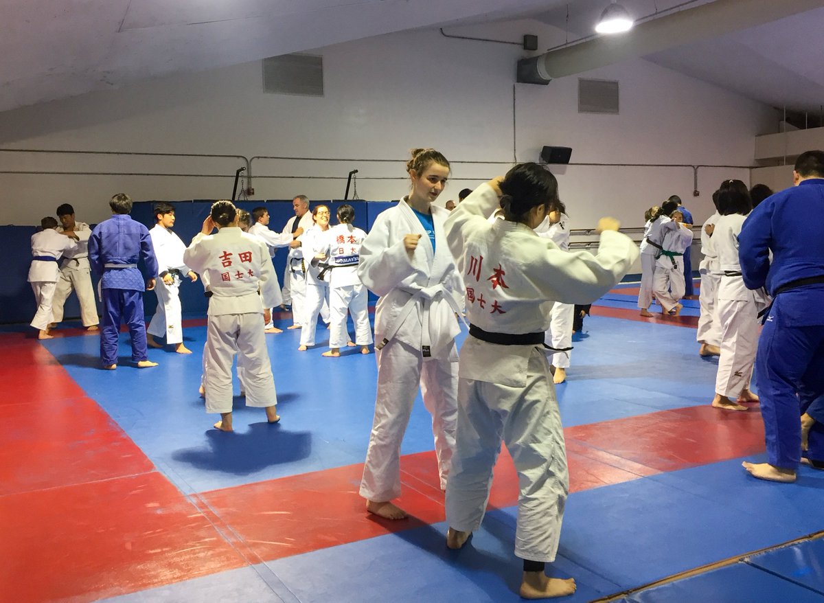 A group of Judo athletes practice in a large open space