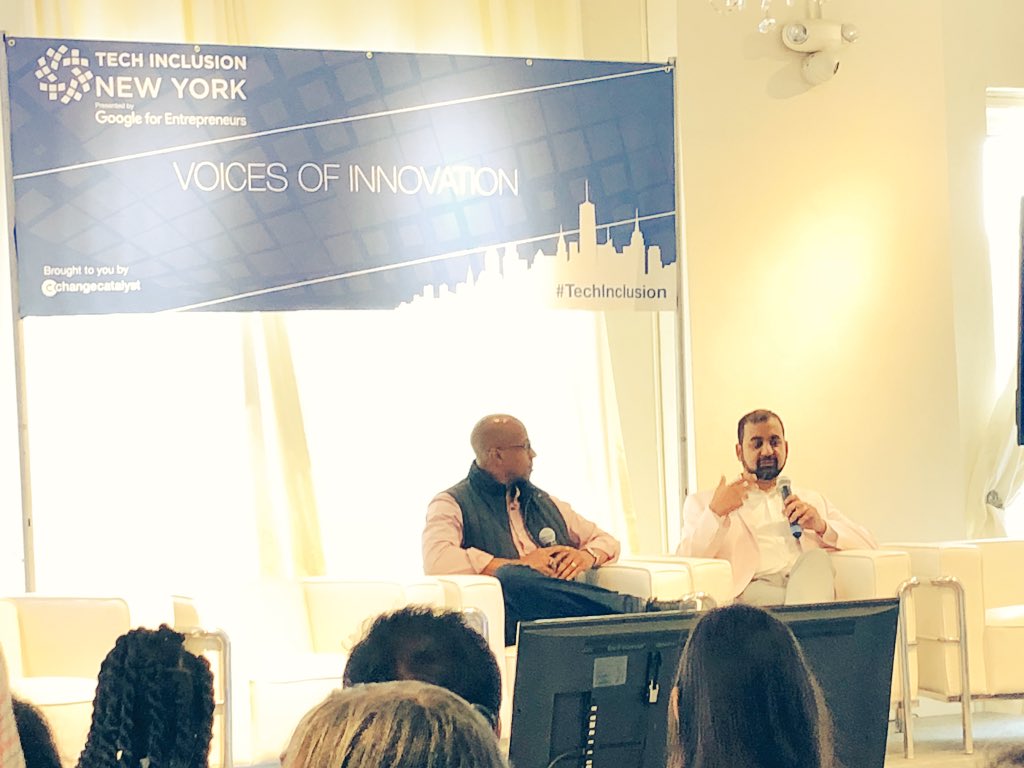 Close up of Anil and Wayne talking on stage