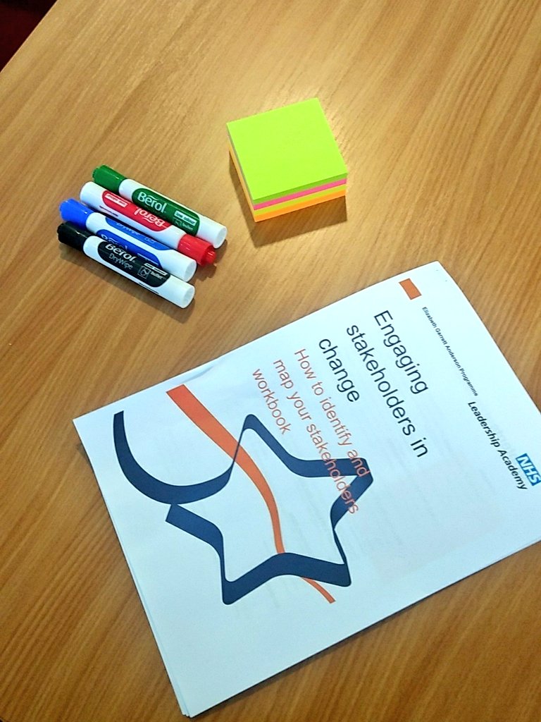 Pens and post it notes on a table with stakeholder engagement instruction booklet.