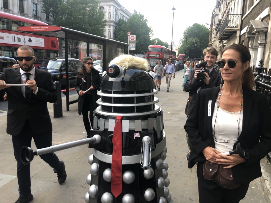 signs_trump's tweet image. There’s a Dalek Trump on Whitehall in London with his own secret service personnel. Great British humour coupled with real anger. #TrumpVisitUK #DrWho