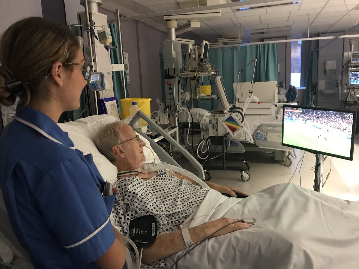 StockportICU's tweet photo. There’s football fever in ICU tonight. Here is Ken, one of our patients, cheering England on with Staff Nurse Sara. (Photo used with patient consent) #stockportnhs #england #football #ICU #worldcup⁠ ⁠ #Proud2Care https://t.co/4XKN8JugZ1