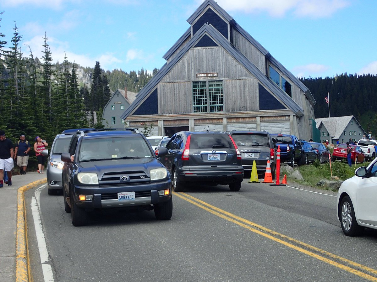 Lines of cars crowd a roadway leading to a visitor center.