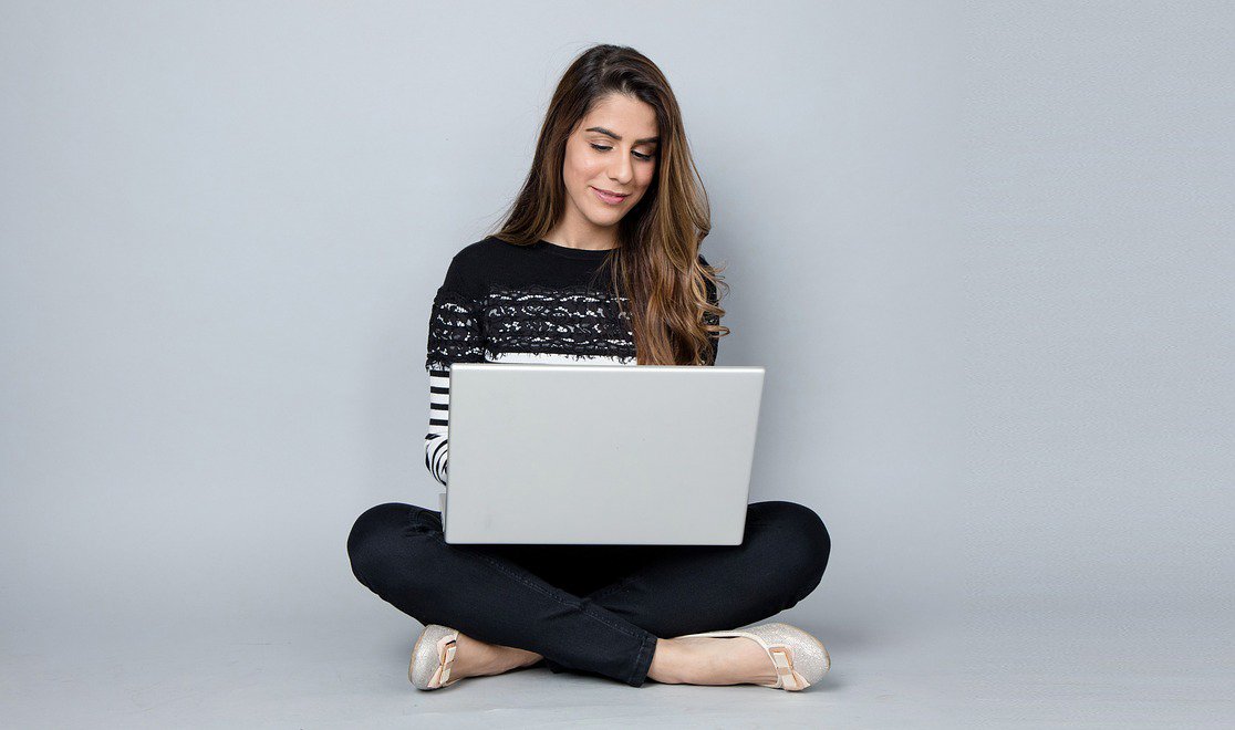 woman sitting on the floor looking at her ocmputer