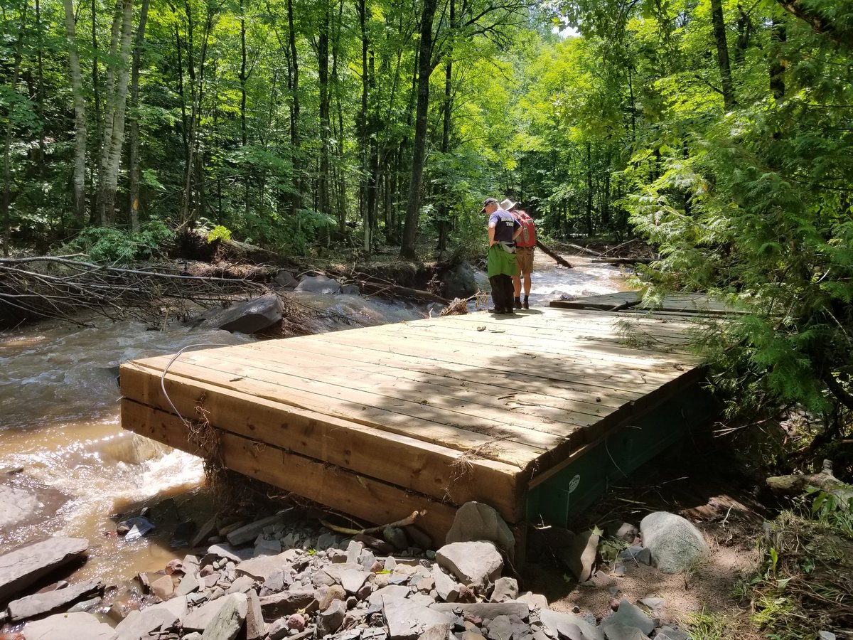 UPTreefarmer's tweet photo. Out at Maasto Hiihto with Mark and John reviewing damage in the Swedetown Creek Gorge and contemplating potential repair and re-route options...here we find the middle bridge some 200 feet downstream! @KNSC_Hancock #MaastoHiihto #Keweenaw #PureMichigan #CCStrong #MDEQ https://t.co/iAfbytAEJ7