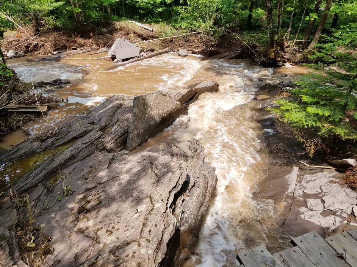 UPTreefarmer's tweet photo. Out at Maasto Hiihto with Mark and John reviewing damage in the Swedetown Creek Gorge and contemplating potential repair and re-route options.  How symbolic that Sisu Bridge would be the only bridge standing! @KNSC_Hancock #Keweenaw #PureMichigan #CCStrong #SisuStrong #MDEQ https://t.co/meP8NIRJEl