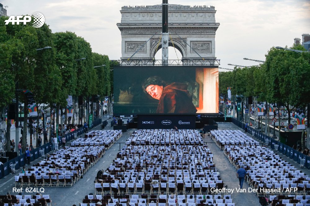 AFP's tweet photo. People watch a movie at the "Un dimanche au cinema" event on the Champs Elysees in Paris https://t.co/xmzaHeXSls