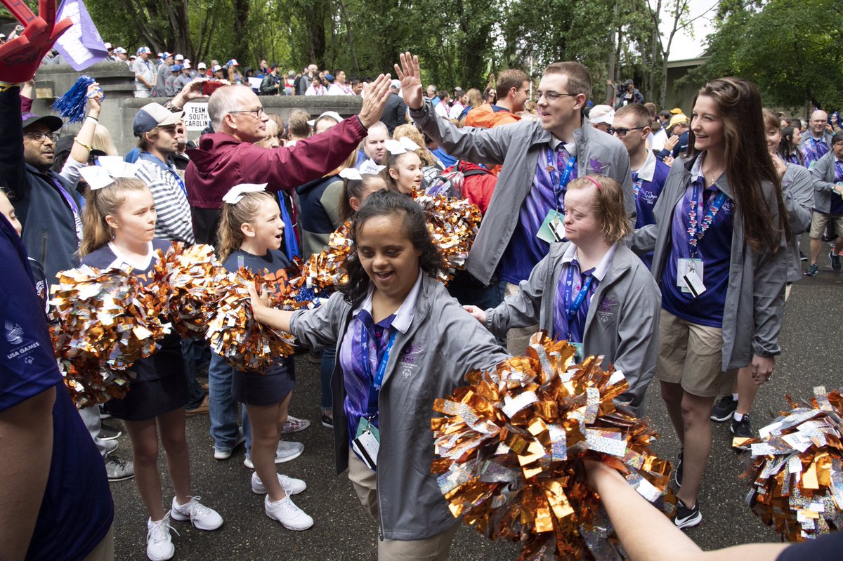 Athlete giving a cheerleader a high five in front of a cheering crowd.