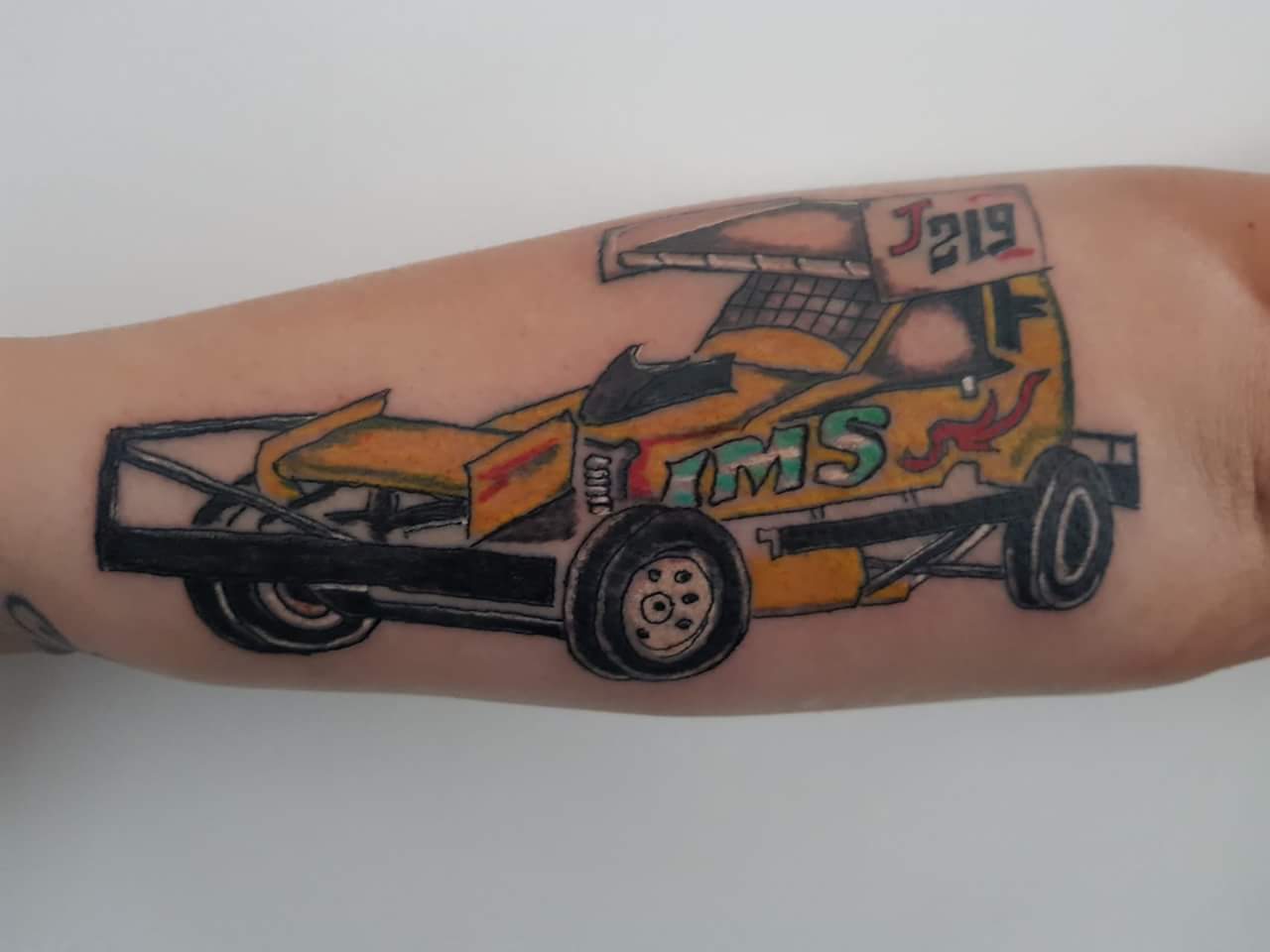 Wooden toy car tattoo on inner arm