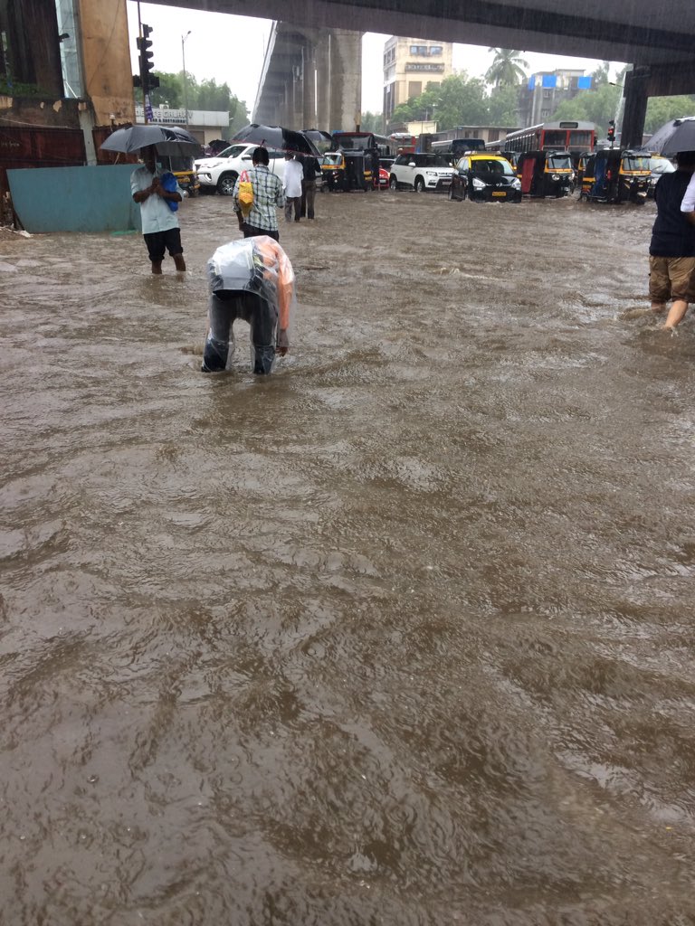 Extragavanza's tweet photo. This is how I have cross and reach. And there are man holes under this water pool. Except that we don't remember where and if they are left open. Just have to keep following a guy ahead of you and if he falls , you take a detour.Proud to be Indian #MumbaiMonsoon #MumbaiRains https://t.co/SBVWE1P4ot
