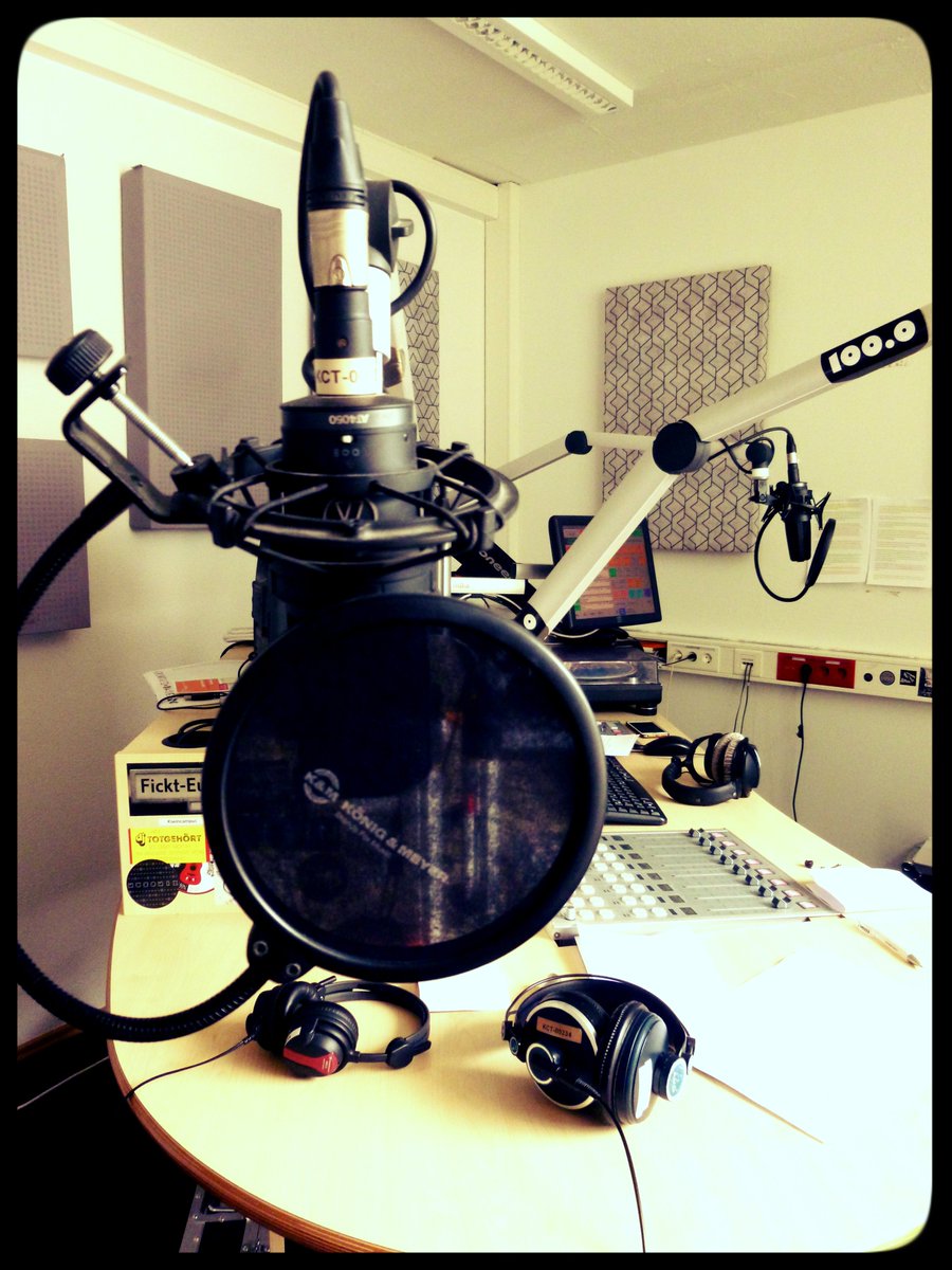 Innenraum eines der Studios. Ein schwarzes Mikrofon und Kopfhörer