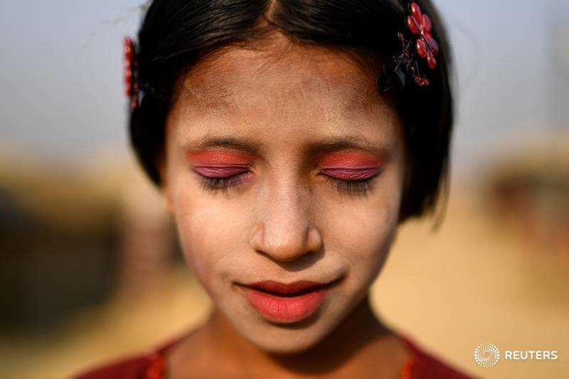 A Rohingya refugee girl named Amina poses for a photograph as she wears thanaka paste at Kutupalong camp in Cox's Bazaar, Bangladesh