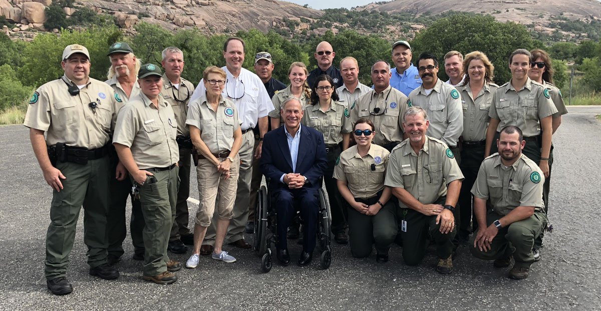 Governor Abbott poses with TPWD staff by Enchanted Rock