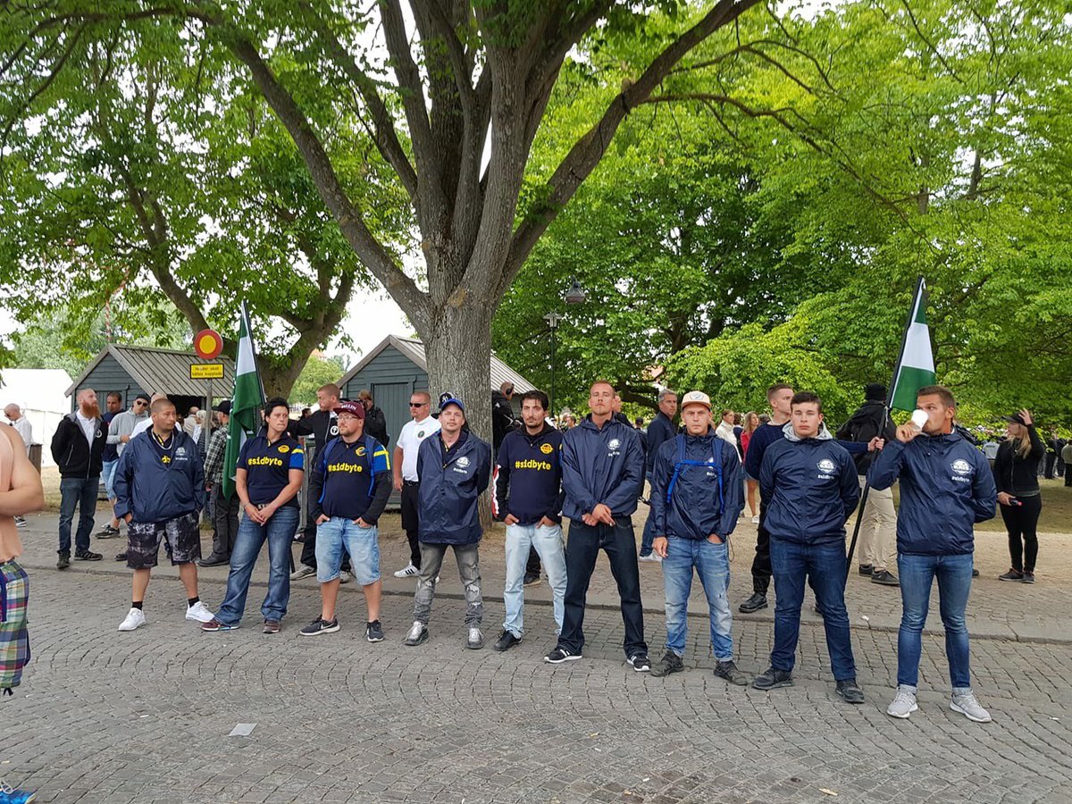 RIKSKRIS's tweet image. Lördag i Almedalen. NMR stod på rad med flaggorna och framför ställde sig medlemmar från KRIS &amp;amp; @ungakris med budskapet på ryggen: #TRYGGARETILLSAMMANS Det var den 4:e dagen som vår närvaro uppmärksammades runt #NMR. #sidbyte #almedalen #ochviprotesterade #svpol #Almedalsveckan