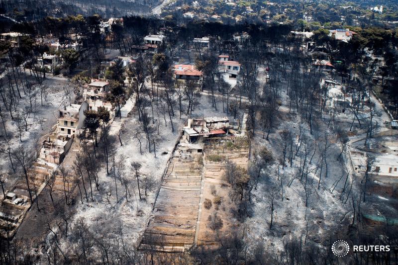 An aerial view of burnt houses and trees in the village of Mati