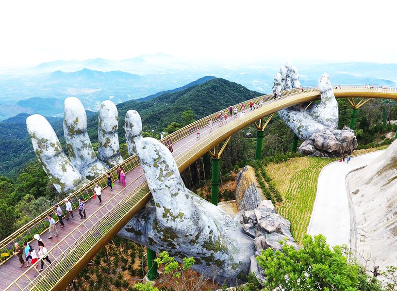 designboom's tweet photo. a giant pair of hands lifts vietnam's da nang golden bridge into the sky https://t.co/3wuBeZ8JO4 https://t.co/Qb3x2biQ39